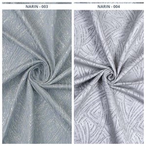 May include: Two close-up shots of textured fabric swatches. The fabric is a light blue-gray color with a subtle, shimmering pattern. The first swatch, labeled "NARIN - 003", has a linear design. The second, "NARIN - 004", features a geometric pattern.