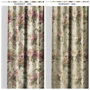 May include: Two floral patterned curtains. The curtains feature a cream-colored background with a repeating pattern of large pink and cream-colored roses and green leaves. The curtains are hanging and have vertical folds.