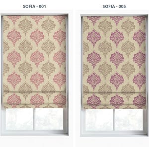 May include: Two window shades with a repeating floral pattern in pink and beige. The shades are mounted inside white window frames. The text "SOFIA - 001" and "SOFIA - 005" are printed at the top of each window.