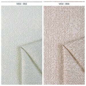 May include: Two fabric samples with a repeating leaf pattern. The sample on the left is light blue and white, while the sample on the right is beige and brown. The fabric is folded to show the underside.