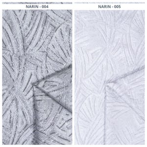 May include: Two fabric samples, labeled NARIN-004 and NARIN-005. NARIN-004 is a gray fabric with a textured, leaf-like pattern. NARIN-005 is a white fabric with a similar textured design. Both fabrics are folded.