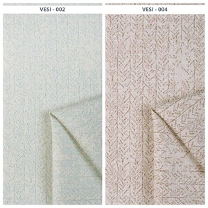 Könnte beinhalten: Zwei Stoffmuster mit einem sich wiederholenden Blattmuster. Das Muster links ist hellblau und weiß, während das Muster rechts beige und braun ist. Der Stoff ist gefaltet, um die Unterseite zu zeigen.