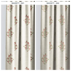 May include: Two beige curtain panels with a repeating floral pattern. The pattern features clusters of pink flowers with green leaves. The curtains are labeled "BASSETT - 001" and "BASSETT - 002" at the top.