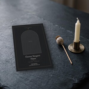 Könnte beinhalten: Ein schwarzes, rechteckiges Trauerprogramm mit einem zentralen Bogenrahmen, goldfarbenen Randlinien und weißem Text: Eleanor Margaret Hayes, March 1948 - 10 January 2024, A Service of Remembrance, St. Andrew's Chapel - Dunsdale, Saturday, 20 January 2024.