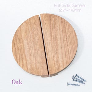 Może przedstawiać: Dwa półkoliste uchwyty meblowe z jasnego drewna dębowego z widocznym usłojeniem. Powyżej znajduje się napis "Full Circle Diameter Ø 7" ≈ 178mm", a poniżej słowo "Oak". W zestawie znajdują się cztery srebrne metalowe śruby montażowe.