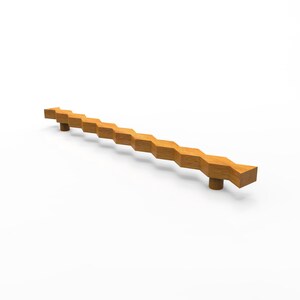 Peut inclure: Une longue poignée de meuble en bois brun clair présentant un motif géométrique répétitif à bords en zigzag sur toute sa longueur. La poignée est soutenue par deux montants cylindriques fixés près de chaque extrémité de la barre en bois.