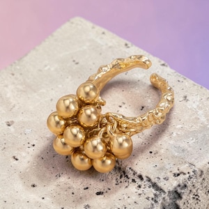 Puede incluir: Una taza de cerámica blanca con un asa negra y el texto "But First, Coffee" en negrita negra. La taza se encuentra sobre un fondo borroso, sugiriendo un ambiente acogedor.