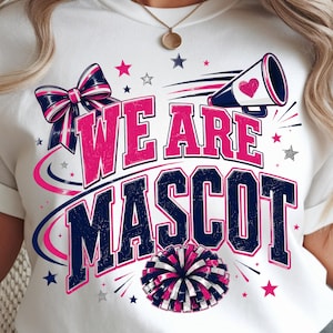 Peut inclure: Un t-shirt blanc avec un motif graphique portant le texte WE ARE MASCOT en rose et bleu marine. Le design comprend un nœud rayé bleu marine et rose, un mégaphone avec un cœur rose, un pompon et des étoiles roses et argentées éparpillées.