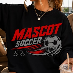 May include: A black crewneck sweatshirt featuring a graphic print with the word MASCOT in large red letters above the word SOCCER in grey. A grey and black football is depicted with red and grey motion lines and a hexagonal pattern design.