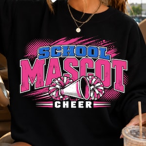 Peut inclure: Un sweat-shirt noir avec une impression graphique portant le texte SCHOOL MASCOT CHEER en bleu et rose. Le motif comprend un mégaphone blanc et des pompons roses et blancs sur un fond au motif rose et noir à l'aspect vieilli.