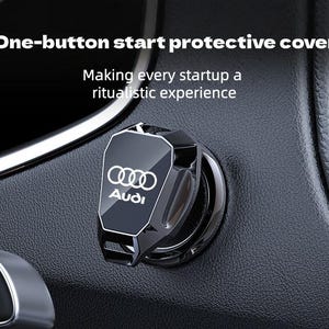 Peut inclure: Un cache de protection noir en forme de bouclier pour bouton de démarrage de voiture, arborant le logo et le texte Audi en blanc. Le texte "One-button start protective cover" et "Making every startup a ritualistic experience" est visible.