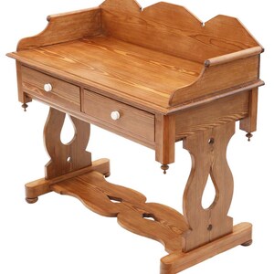 May include: A wooden desk with two drawers and a scalloped back. The desk is made of light brown wood and has white knobs on the drawers. The legs have a decorative, curved design. The desk is approximately 40 inches wide.