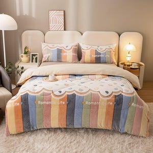 Peut inclure: Un lit avec une couverture colorée et deux oreillers assortis. La couverture présente des rayures verticales dans les tons orange, bleu, vert et jaune. Les oreillers et la couverture portent l'inscription "Romantic Life". Le lit est sur un tapis blanc moelleux.