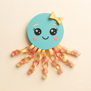 May include: A paper craft octopus featuring a circular teal head with a yellow bow, large black eyes with white star accents, and two small orange star cheeks. Eight tentacles extend from the head, constructed from interlocking yellow and orange paper loops.