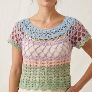 Puede incluir: Un top de ganchillo en colores pastel con cuello redondo y mangas cortas. El top presenta un degradado de colores, incluyendo azul, lavanda, rosa y verde. El diseño de tejido abierto añade una sensación delicada y aireada a la prenda.