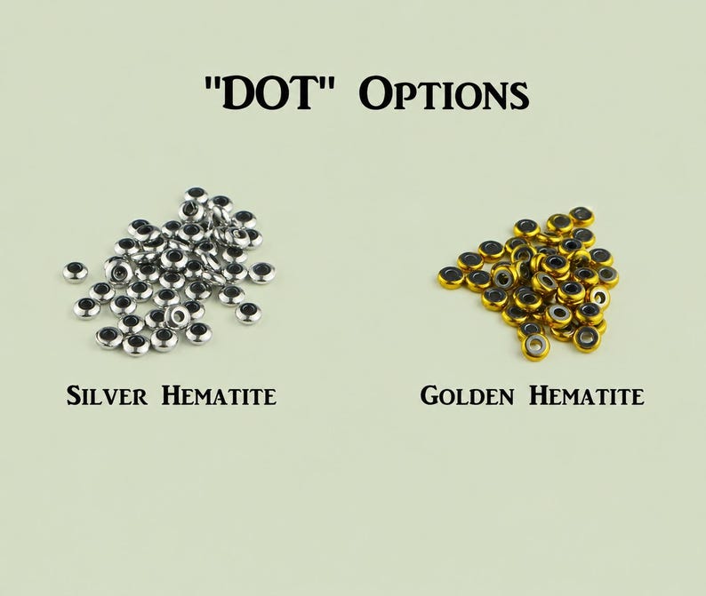 May include: Two piles of small, round, donut-shaped beads labeled "DOT" OPTIONS. The left pile consists of silver-colored hematite beads, labeled "SILVER HEMATITE". The right pile consists of gold-colored hematite beads, labeled "GOLDEN HEMATITE".