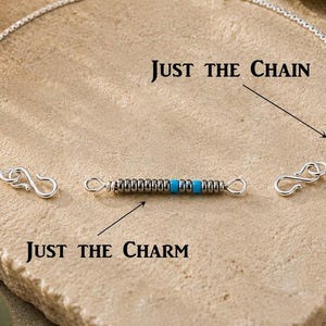 May include: A silver box chain necklace with S-hooks at both ends and a separate cylindrical charm featuring alternating metallic silver and bright turquoise beads. The text "JUST THE CHAIN" and "JUST THE CHARM" labels the components.