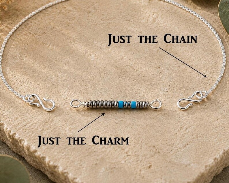 May include: A silver box chain necklace with S-hooks at both ends and a separate cylindrical charm featuring alternating metallic silver and bright turquoise beads. The text "JUST THE CHAIN" and "JUST THE CHARM" labels the components.