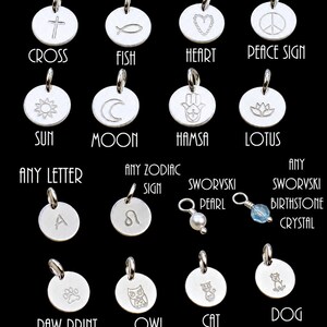 May include: A collection of silver-toned circular charms featuring engraved symbols including a cross, fish, heart, peace sign, sun, moon, hamsa, lotus, letter A, zodiac sign, paw print, owl, cat, dog, a pearl, and a light blue crystal birthstone.