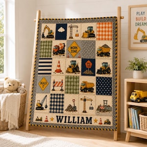 Op de afbeelding: Een patchwork quilt met bouwvoertuigen, verkeersborden en patronen in marineblauw, oranje en groen. De quilt toont illustraties van graafmachines, kiepwagens en kranen, met de naam WILLIAM in dikke marineblauwe letters aan de onderkant.
