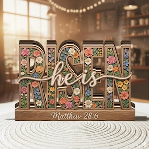 May include: A white ceramic mug with a black handle and the text "But First, Coffee" in a handwritten style. The mug is on a white surface. The mug is approximately 10 cm tall.