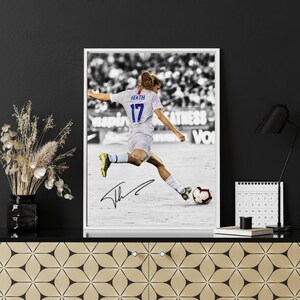 May include: Black and white framed print of a soccer player in action, kicking a soccer ball. The player wears a white jersey with the number 17 and the name "Heath". The print includes an autograph.