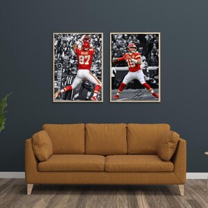 Puede incluir: Dos impresiones enmarcadas con jugadores de fútbol en acción. Una muestra a un jugador con uniforme rojo atrapando un balón, la otra muestra a un jugador lanzando un balón. Ambos están en acción con un fondo en blanco y negro. Los marcos son de color marrón claro y las imágenes se muestran sobre un sofá marrón.