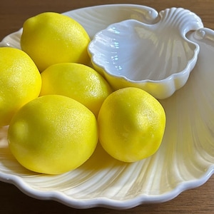 May include: A white ceramic mug with a black handle and the text "But First, Coffee" in a handwritten style. The mug is on a white surface. The mug is approximately 4 inches tall.