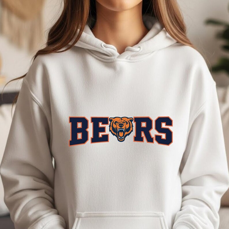 May include: White hoodie with the word "BEARS" in navy blue block letters with an orange bear head logo in the center. The hoodie has a drawstring hood and long sleeves.