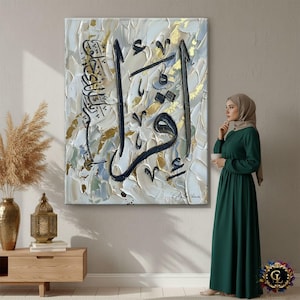 Peut inclure: Grande peinture abstraite avec calligraphie arabe noire sur fond texturé blanc, or et gris. L'œuvre est exposée sur un mur. Une femme en robe verte et hijab se tient à proximité.