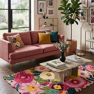 Unique wavy border irregular floral rug styled with a marble table and green plants for an aesthetic home look