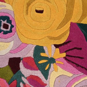 Detailed texture of a plush colorful flower carpet showing high-quality hand-tufting and soft wool fibers.
