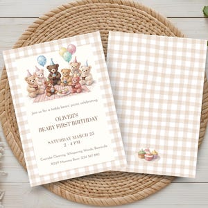 Può includere: Invito di compleanno a tema picnic di orsetti. L'invito presenta un gruppo di orsetti che festeggiano con palloncini e cupcake. Il testo recita "Beary First Birthday di Oliver" e include data, ora e informazioni RSVP.