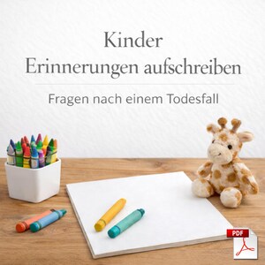 May include: A still life featuring a white square container filled with colorful crayons, a plush giraffe, and a blank white paper on a wooden surface. Two crayons are lying on the paper. The image has text that reads "Kinder Erinnerungen aufschreiben Fragen nach einem Todesfall".