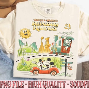 May include: Cream-colored t-shirt featuring a colorful cartoon design. The graphic includes Mickey and Minnie Mouse in a red car, a train, a smiling sun, and the text "Mickey & Minnie's Runaway Railway".