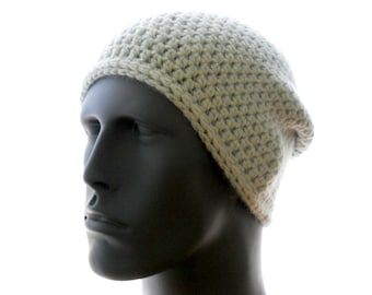 May include: A light beige crochet beanie hat. The hat is made of a thick yarn and has a ribbed brim. The hat is shown on a mannequin head. The hat is a neutral color and can be worn by anyone.