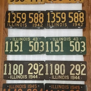 May include: A collection of vintage Illinois license plates from the 1940s. The plates are in various colors, including yellow, black, green, and brown. The plates feature the state name and year of issue.  The plates are in good condition and would be a great addition to any collection.