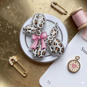 May include: A set of three ceramic mugs with a speckled, matte finish. The mugs are in shades of cream, light gray, and dark gray. Each mug has a simple, minimalist design, perfect for coffee or tea.