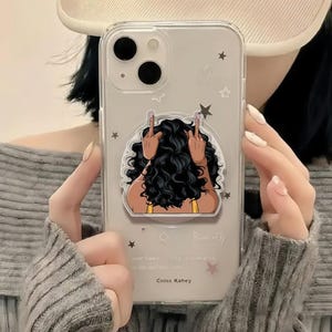 May include: A white ceramic mug with a black handle and the text "But First, Coffee" in a black, handwritten-style font. The mug is on a white surface.