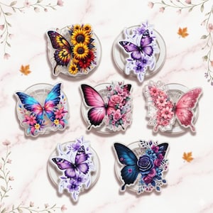 May include: Seven decorative butterfly accessories, each with a butterfly design and floral accents in various colours, including pink, blue, purple, and yellow. The butterflies are set against a white background.