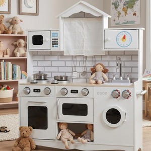 May include: A white wooden toy kitchen set with a microwave, oven, stove, and sink. The set includes a play clock, a small curtain, and various toy pots and pans. Stuffed animals and dolls are placed around the kitchen.