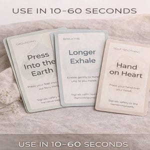 May include: Three cards with text, including "Press Into the Earth," "Longer Exhale," and "Hand on Heart." The cards are light-colored with a soft, blurred background. The text "USE IN 10-60 SECONDS" is at the top and bottom of the image.