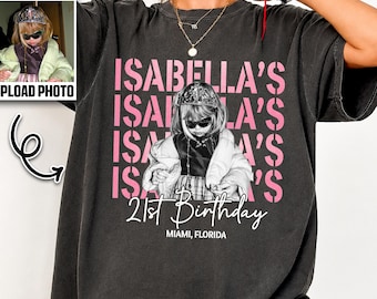May include: A charcoal gray short-sleeve t-shirt featuring a repeating pink text graphic that reads ISABELLA'S, a central black and white photograph of a person wearing a tiara and sunglasses, and white text reading 21st Birthday MIAMI, FLORIDA.