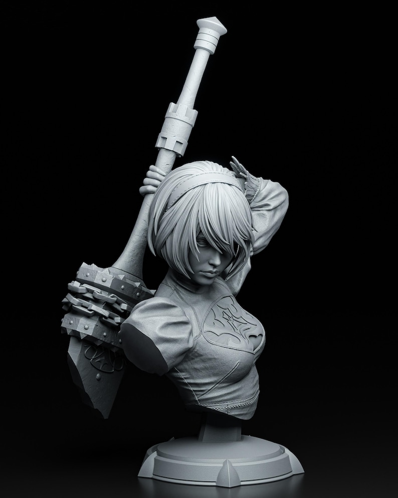 Peut inclure: Buste gris d'une figurine f&eacute;minine tenant une grande arme. La figurine a les cheveux courts et porte un haut d&eacute;taill&eacute;. L'arme a une t&ecirc;te &agrave; pointes et est tenue au-dessus de l'&eacute;paule du personnage. La sculpture est sur une base ronde.
