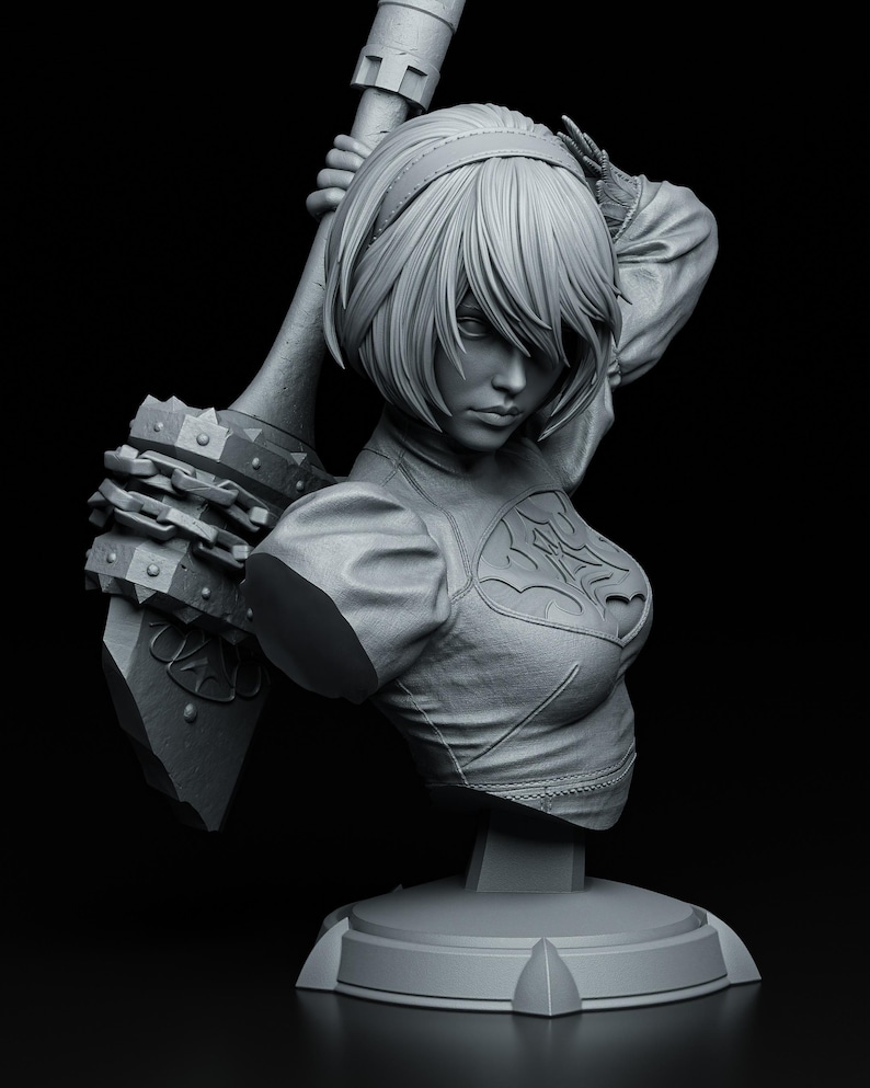 Peut inclure: Buste en niveaux de gris d'un personnage f&eacute;minin aux cheveux courts, tenant une grande arme. La figurine porte une tenue d&eacute;taill&eacute;e avec un embl&egrave;me d&eacute;coratif sur la poitrine. Le buste est mont&eacute; sur une base ronde sur fond noir.