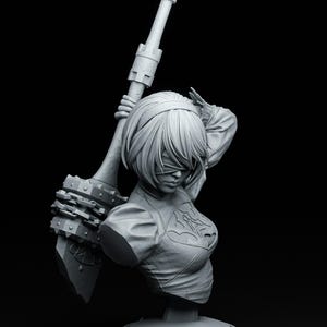 Pode incluir: Escultura de busto em tons de cinza de uma figura feminina com cabelo curto e uma venda nos olhos, segurando uma arma grande. A figura está vestindo um top detalhado com um design decorativo. A escultura é montada em uma base circular, em um fundo preto.