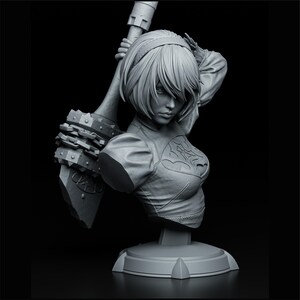 Peut inclure: Buste en niveaux de gris d'un personnage f&eacute;minin avec des cheveux courts, un bandeau et une tenue d&eacute;taill&eacute;e. Elle tient une grande arme avec un bord &agrave; pointes. La sculpture est mont&eacute;e sur une base ronde.