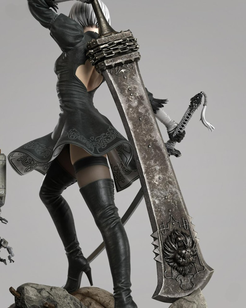 May include: A detailed figurine of a character wearing a black dress with a cutout back, black thigh-high boots, and white gloves. The character holds a large, weathered metallic sword featuring a lion head emblem and a smaller sword in the other hand.