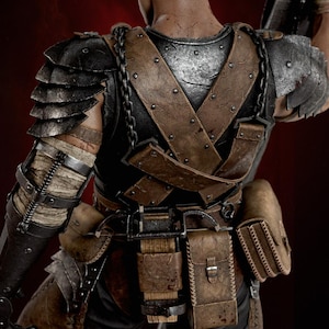 May include: A detailed action figure seen from the back, wearing dark metallic shoulder armor, a black chest plate with brown leather straps, and a belt equipped with multiple brown leather pouches and a small wooden block component.