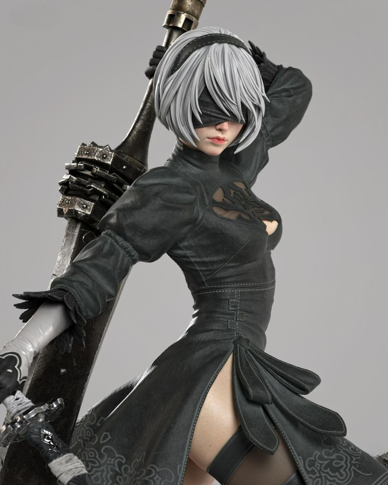 May include: A detailed collectible figurine of a character with short white hair, wearing a black dress with a chest cutout, a black blindfold, and white gloves. The figure holds a large, weathered metallic sword resting against their back.